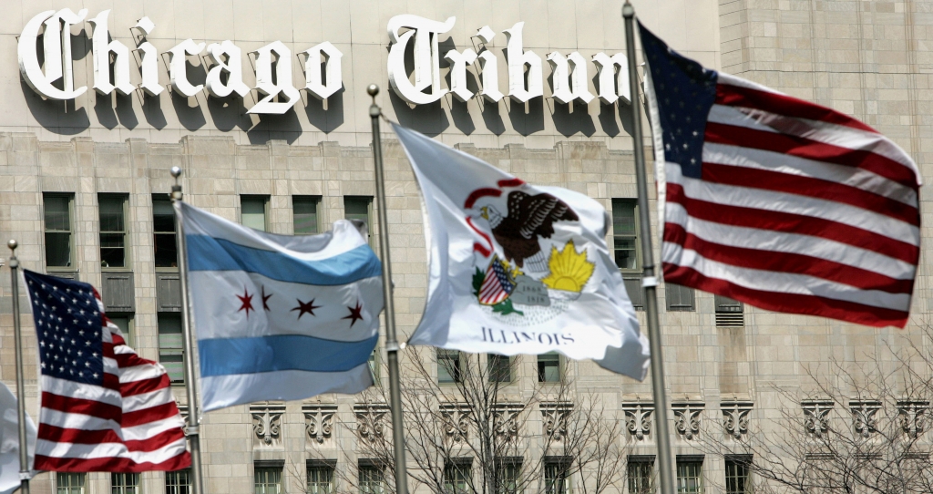 FILE - In this April 12, 2006, file photo, flags wave near the Chicago Tribune Tower in downtown Chicago. A week after naming a new CEO, Tribune Publishing Co. announced a reorganization, on Wednesday, March 2, 2016, naming each of its newspapers' editors as dual editors-in-chief and publishers. (AP Photo/Charles Rex Arbogast, File)
