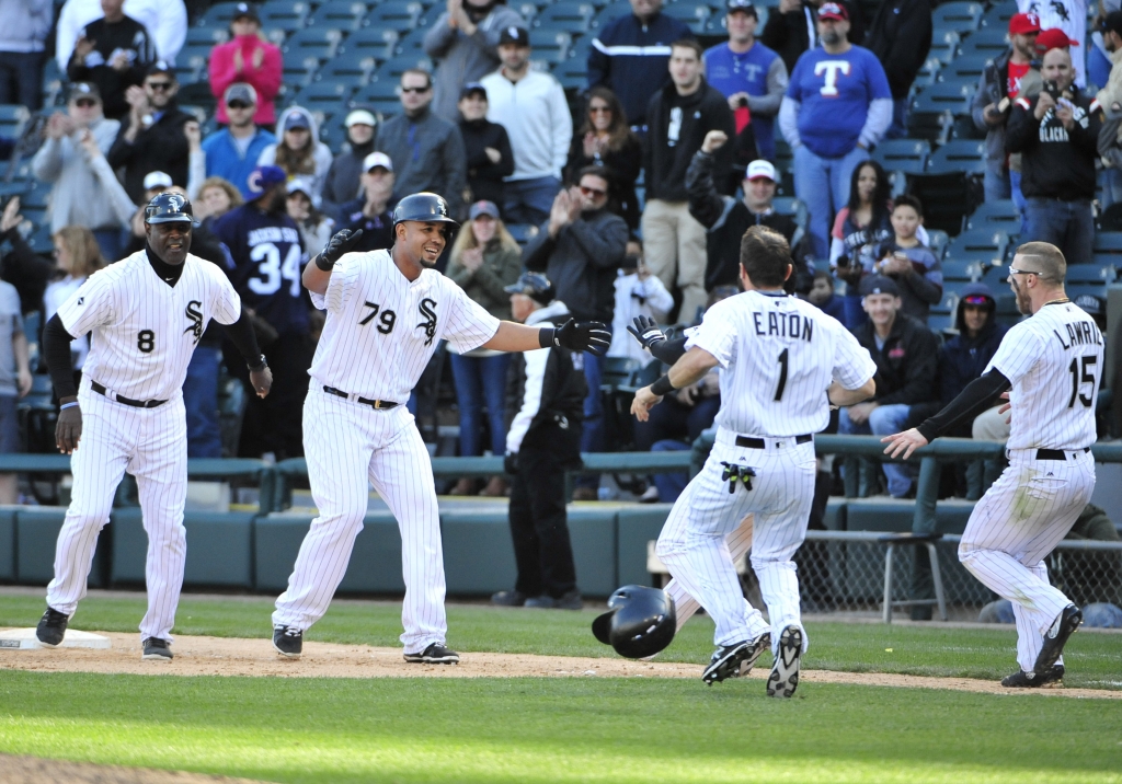 Chicago White Sox's Jose Abreu (79), celebrates his game winning single with Adam Eaton (1) and Brett Lawrie (15) against the Texas Rangers during the eleventh inning of a baseball game, Saturday, April 23, 2016, in Chicago.The White Sox won 4-3 in eleven innings. (AP Photo/David Banks)